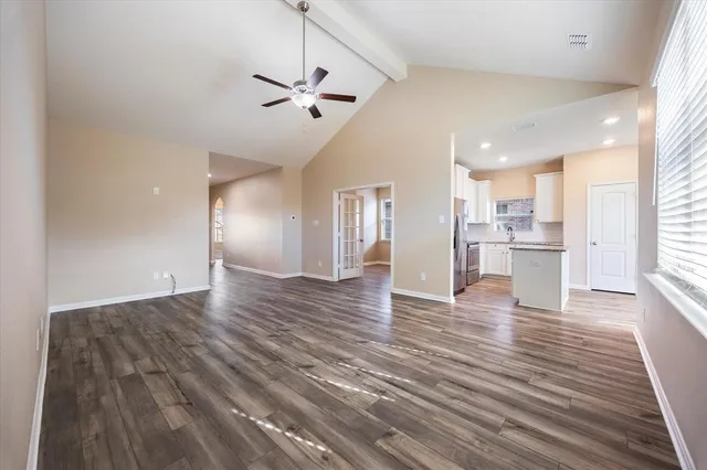 a view of a room that has wooden floor and cabinets