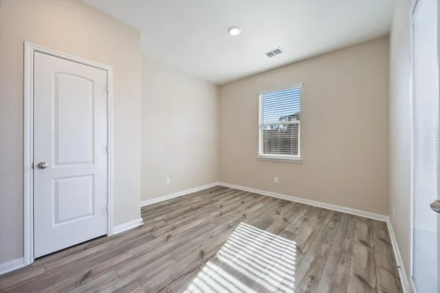 a view of empty room with window and ceiling fan