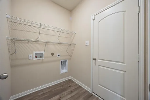 an empty room with wooden floor chandelier fan and windows
