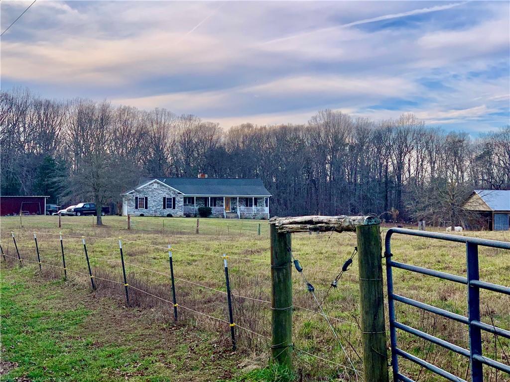 6911 Alexander Farm Road Monroe, NC 28110 - Photo 2 of 48 a view of a swimming pool with a yard and large trees