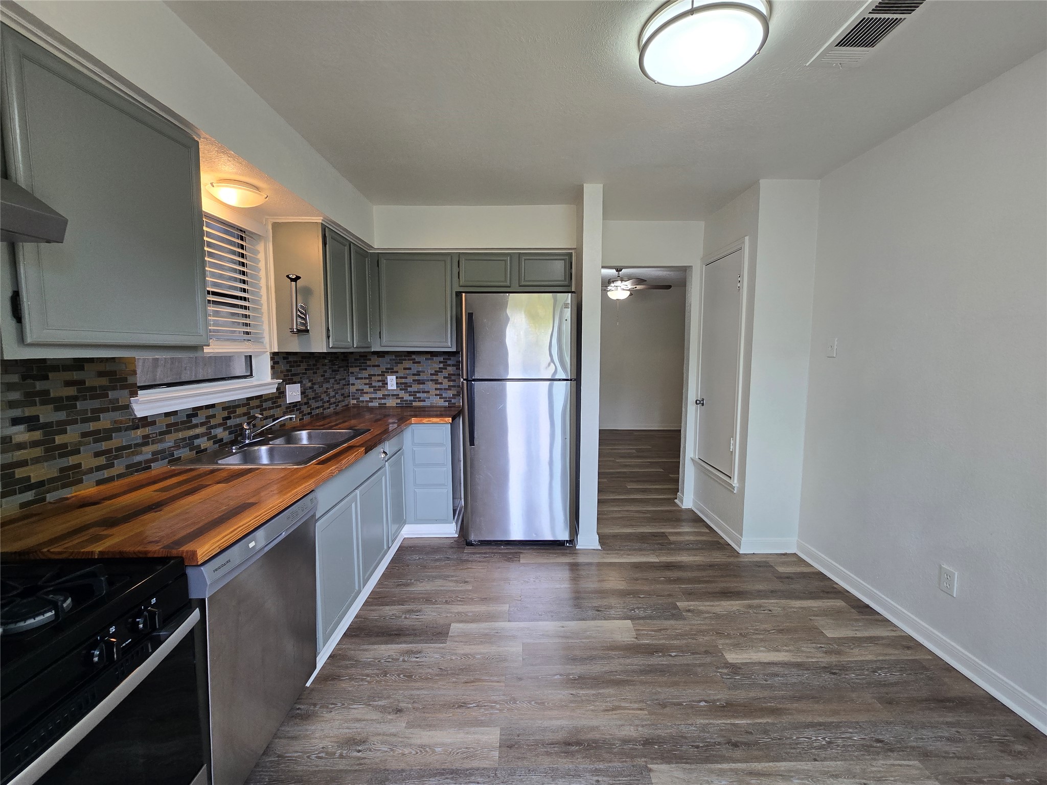 2003 Kenneth Avenue, Unit B Austin, TX 78741 - Photo 4 of 19 Rich wood countertops contrast beautifully with sleek grey cabinetry and durable plank flooring.