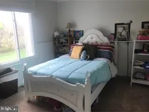 a bed sitting in a bedroom next to a window