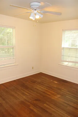 a view of a room with wooden floor and a window
