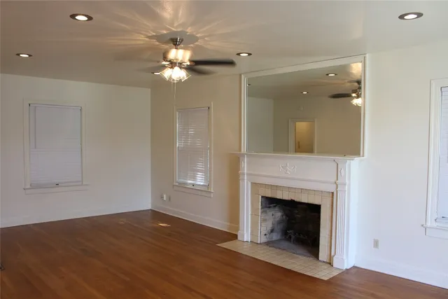 a view of a livingroom with a fireplace wooden floor and a chandelier fan
