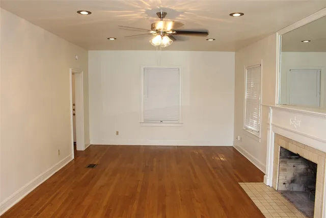 an empty room with a fireplace and wooden floor