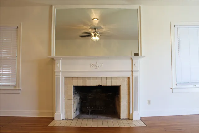a living room with a fireplace and a ceiling fan