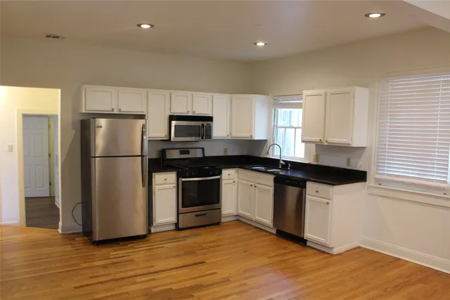 a kitchen with granite countertop a refrigerator and a stove top oven