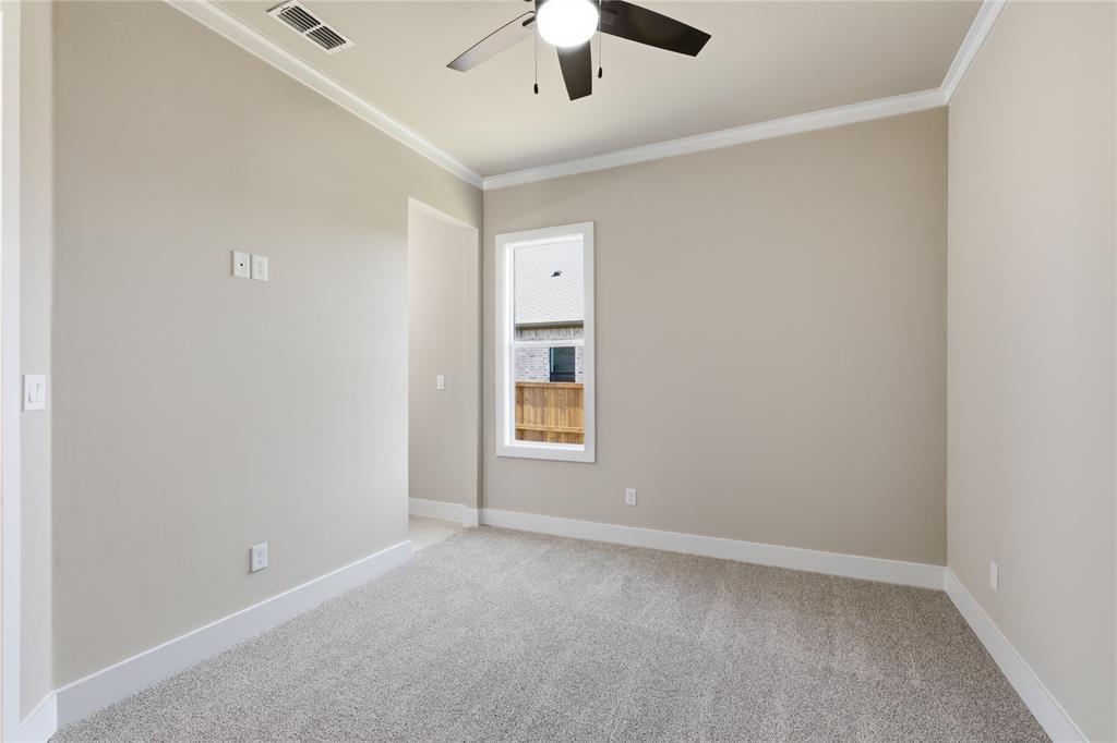 709 Anne Road Van Alstyne, TX 75495 - Photo 11 of 28 Carpeted room with neutral paint, a single window, a ceiling fan with integrated lighting, white baseboards, and crown molding