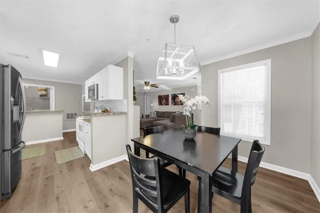 a dining room with furniture a chandelier and wooden floor