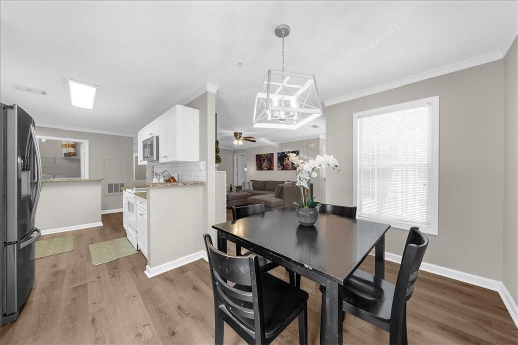123 Streamside Drive Roswell, GA 30076 - Photo 18 of 36 a dining room with furniture a chandelier and wooden floor