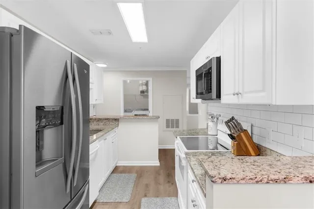 a kitchen with stainless steel appliances granite countertop a refrigerator and a sink