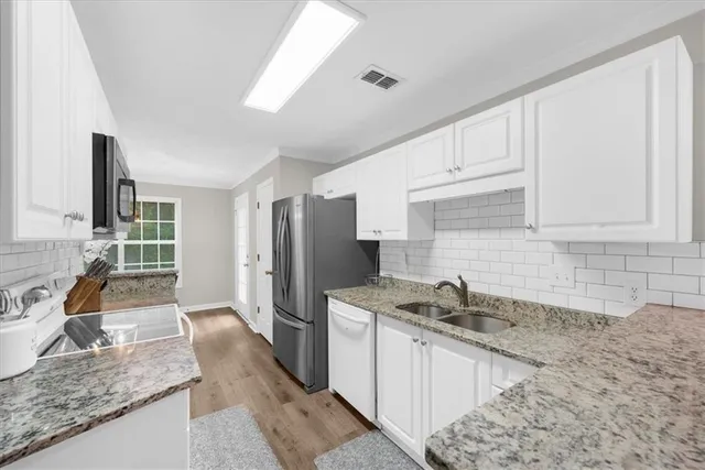 a kitchen with stainless steel appliances granite countertop a sink stove and refrigerator