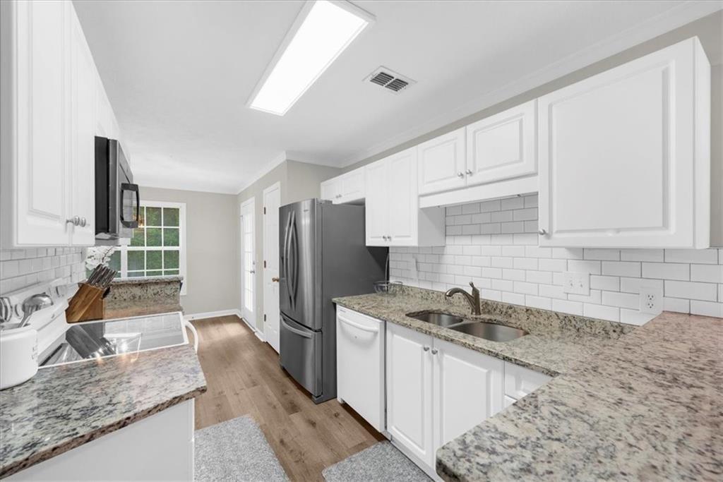 123 Streamside Drive Roswell, GA 30076 - Photo 22 of 36 a kitchen with stainless steel appliances granite countertop a sink stove and refrigerator