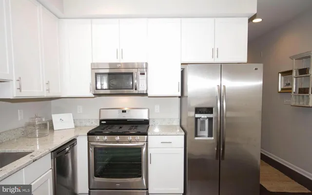 a kitchen with cabinets and stainless steel appliances
