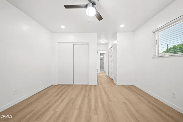 a view of hallway with wooden floor and ceiling fan