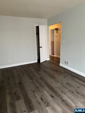 an empty room with wooden floor and closet