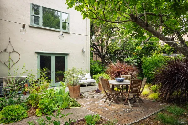 a view of a house with a yard and potted plants