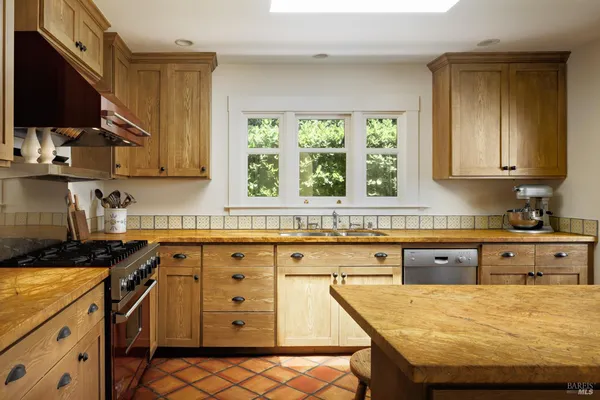 a kitchen with a table chairs refrigerator and cabinets