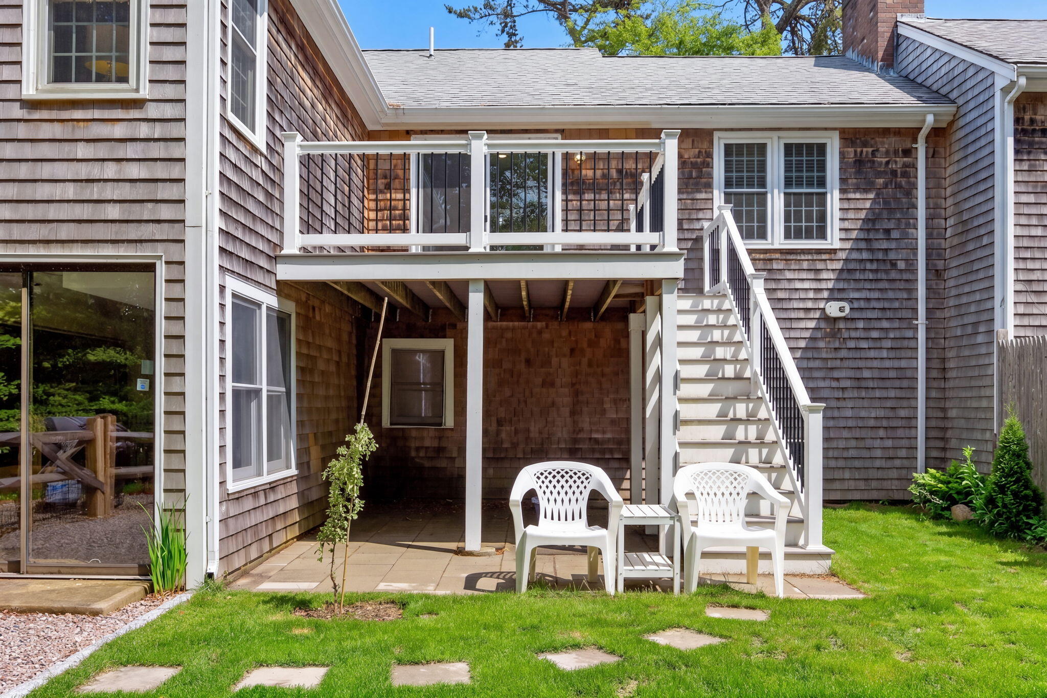 35 Debs Hill Road, Unit 35 Yarmouth Port, MA 02675 - Photo 32 of 36 a couple of table and chairs in front of a house