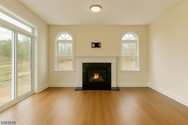 a view of an empty room with a window and fireplace