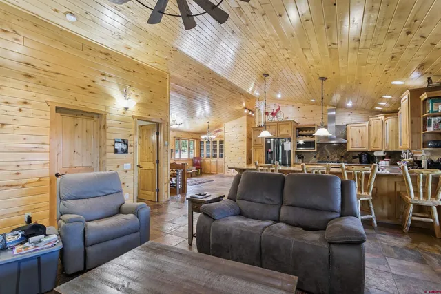 a living room with furniture and a view of kitchen