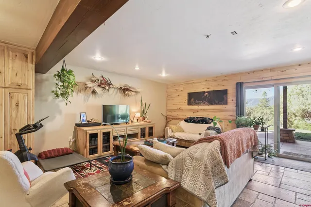 a living room with furniture a fireplace and a floor to ceiling window
