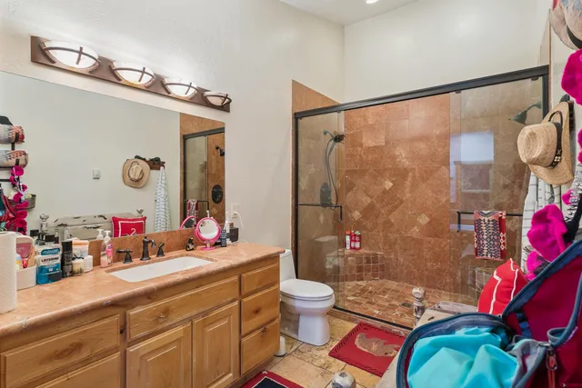 a bathroom with a granite countertop sink mirror vanity and toilet