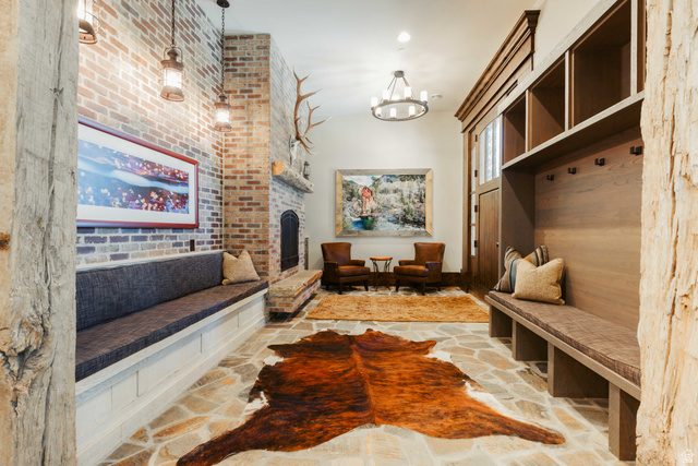 1667 West Tollgate Cyn Road Coalville, UT 84017 - Photo 15 of 61 Spacious mudroom featuring flagstone flooring, a large brick fireplace, built-in bench seating, and an integrated wood-finish storage system with cubbies and hooks