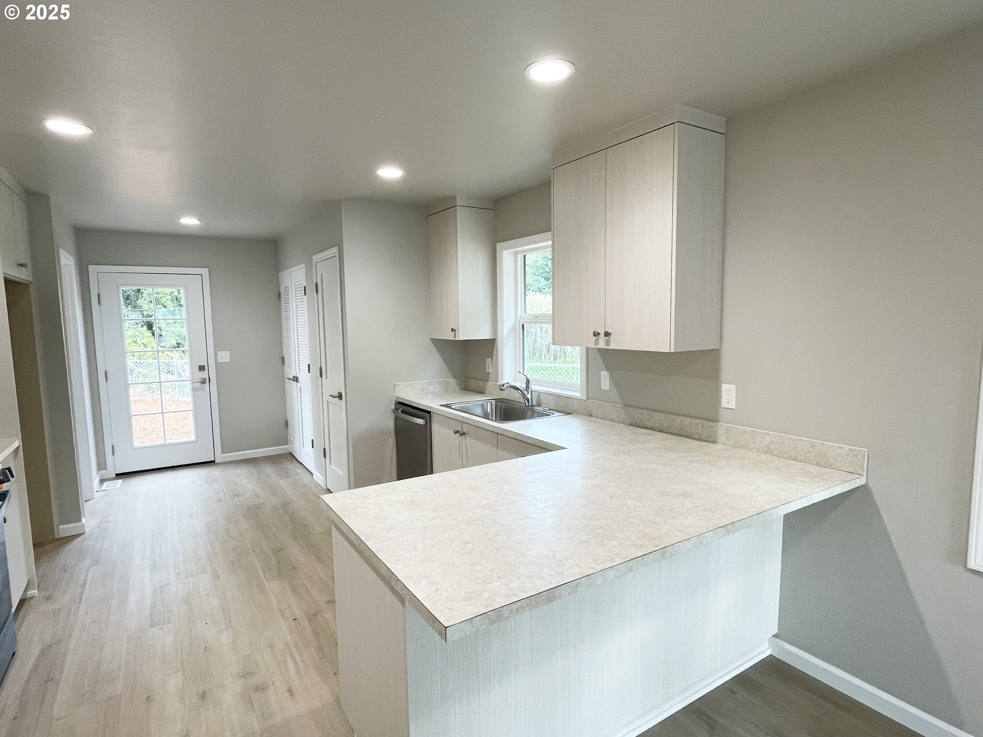 310 North Chase Street Heppner, OR 97836 - Photo 4 of 14 a large kitchen with kitchen island a stove a sink a refrigerator and white cabinets with wooden floor
