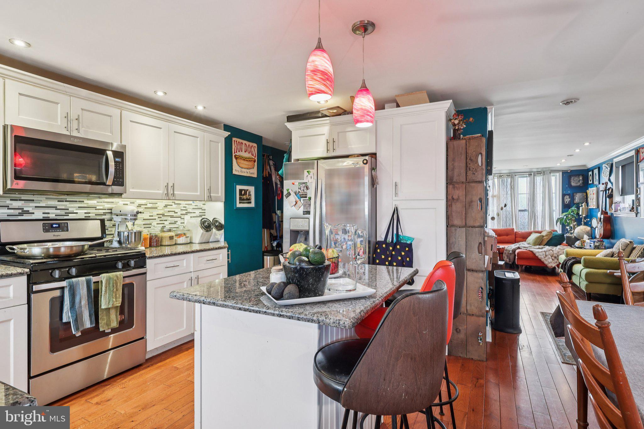 3442 Holyoke Road Philadelphia, PA 19114 - Photo 16 of 35 a kitchen with stainless steel appliances kitchen island granite countertop a stove a sink dishwasher a dining table and chairs with wooden floor
