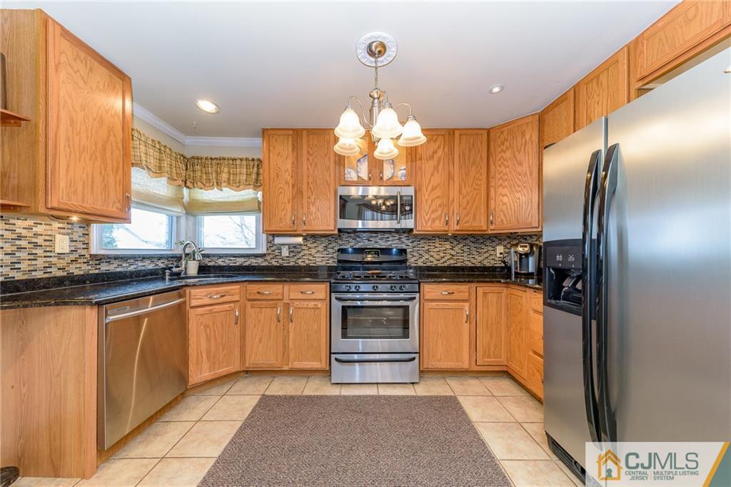 7 Exeter Road Fords, NJ 08863 - Photo 6 of 25 a kitchen with stainless steel appliances granite countertop a refrigerator a stove and a sink