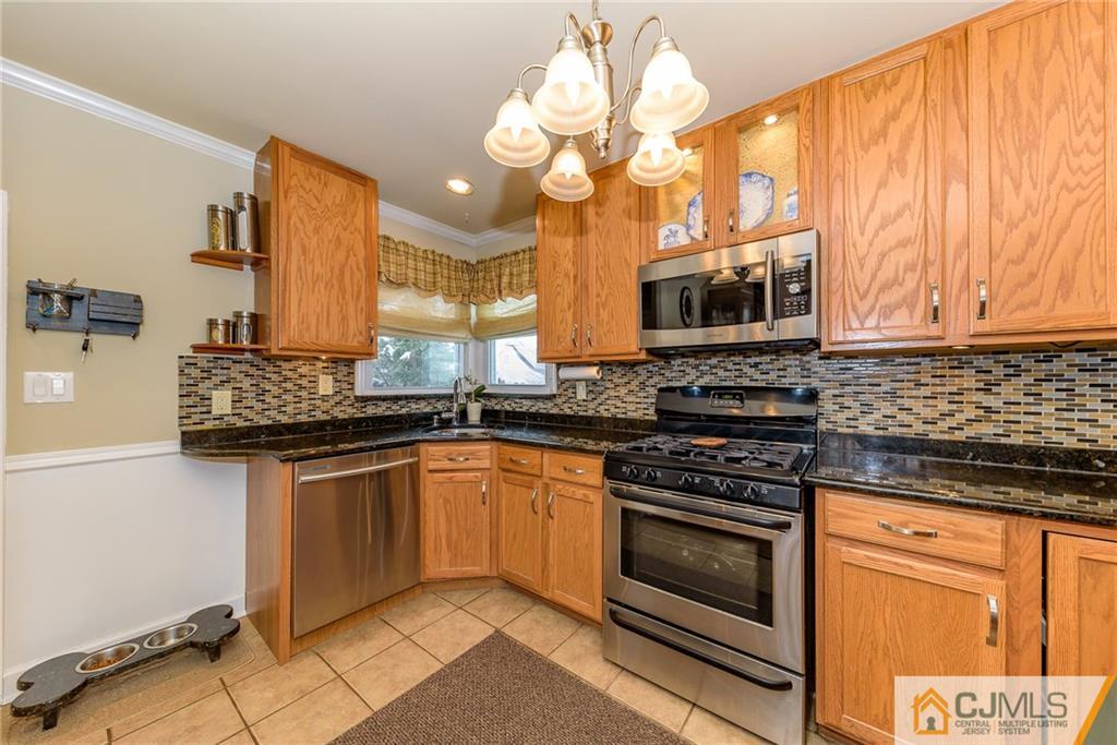 7 Exeter Road Fords, NJ 08863 - Photo 8 of 25 a kitchen with stainless steel appliances granite countertop a stove top oven microwave and cabinets
