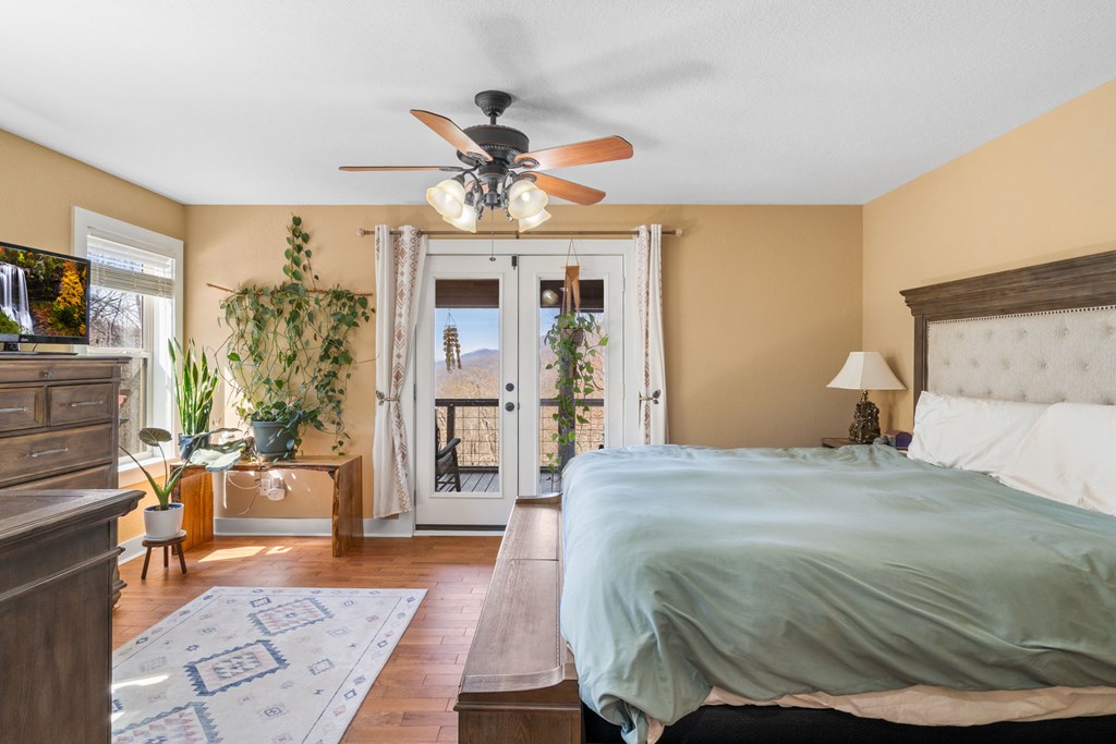 961 South Brooks Cove Road Hayesville, NC 28904 - Photo 17 of 55 a bedroom with a large bed and a chandelier