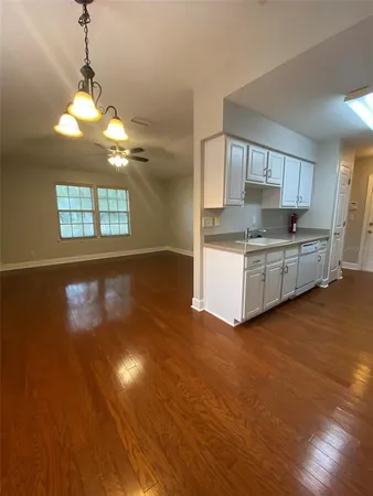 a kitchen with stainless steel appliances granite countertop a stove a sink dishwasher and a oven with white cabinets