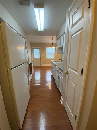 a view of a hallway with wooden floor