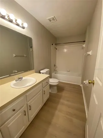 a bathroom with a double vanity sink toilet mirror and bathtub