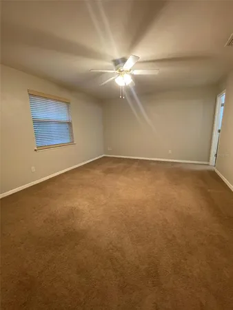 an empty room with windows and fan