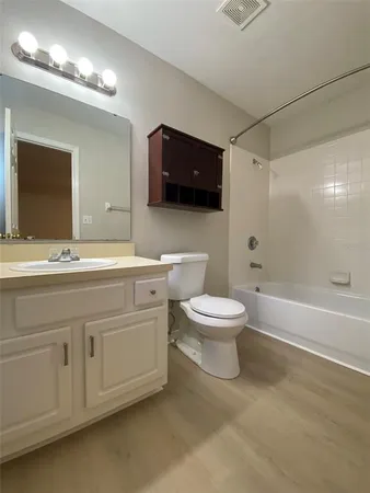 a bathroom with a toilet a sink a mirror and a bathtub
