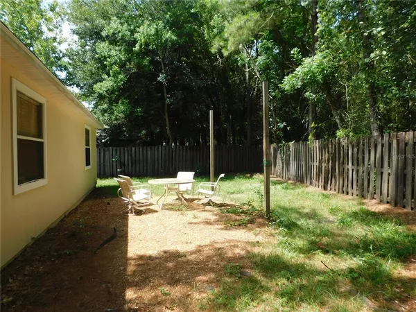 a backyard of a house with table and chairs