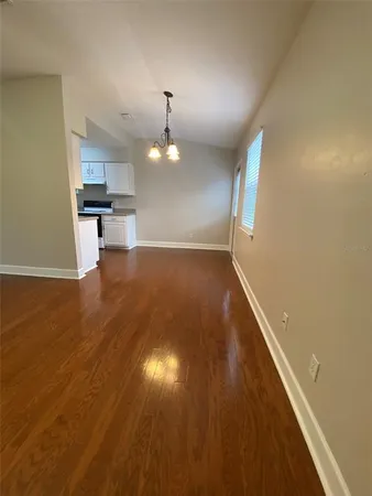 a view of empty room with wooden floor