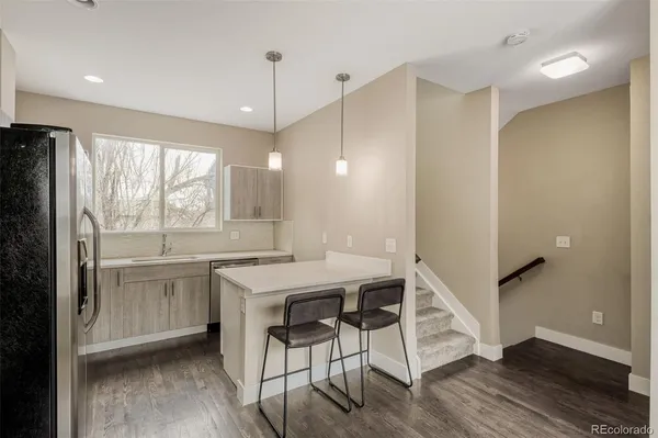 a kitchen with a table chairs refrigerator and microwave