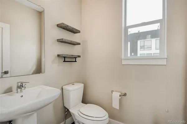 a bathroom with a toilet a sink and mirror