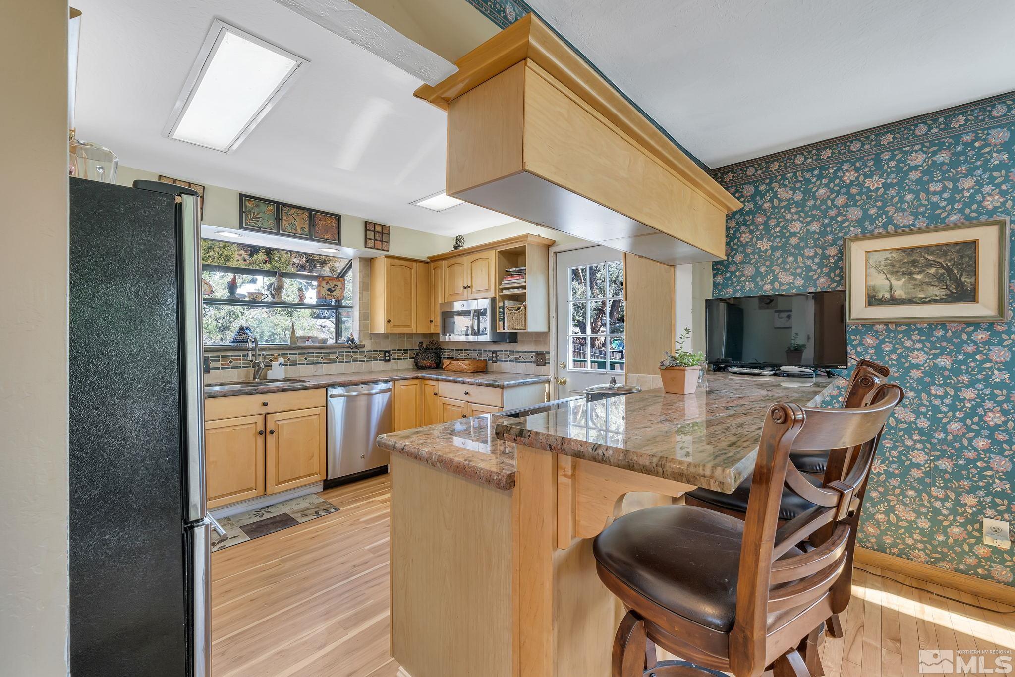 14615 Virginia Foothills Drive Reno, NV 89521 - Photo 16 of 27 a kitchen with a table chairs refrigerator and cabinets
