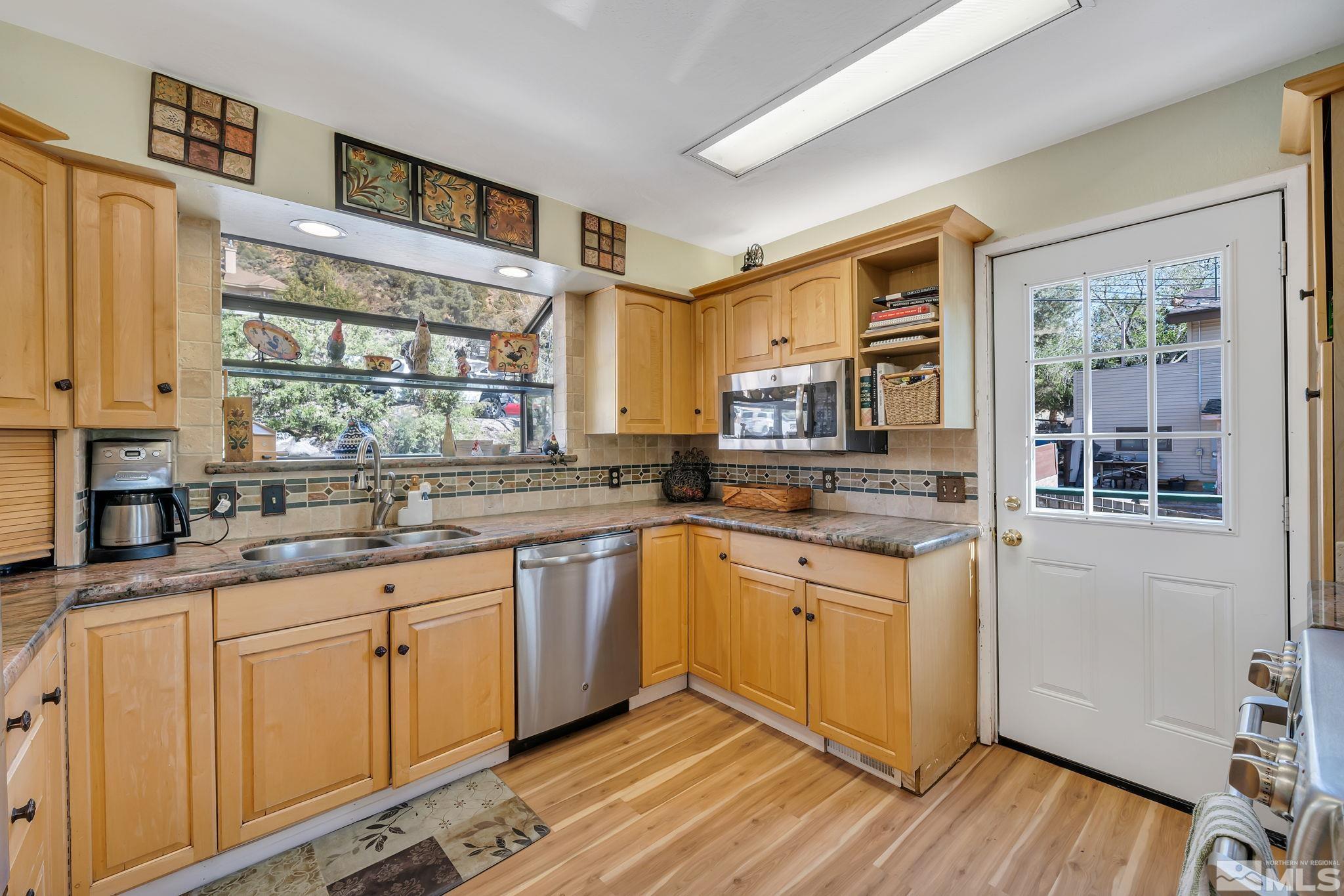 14615 Virginia Foothills Drive Reno, NV 89521 - Photo 20 of 27 a kitchen with granite countertop a sink cabinets stainless steel appliances and a large window