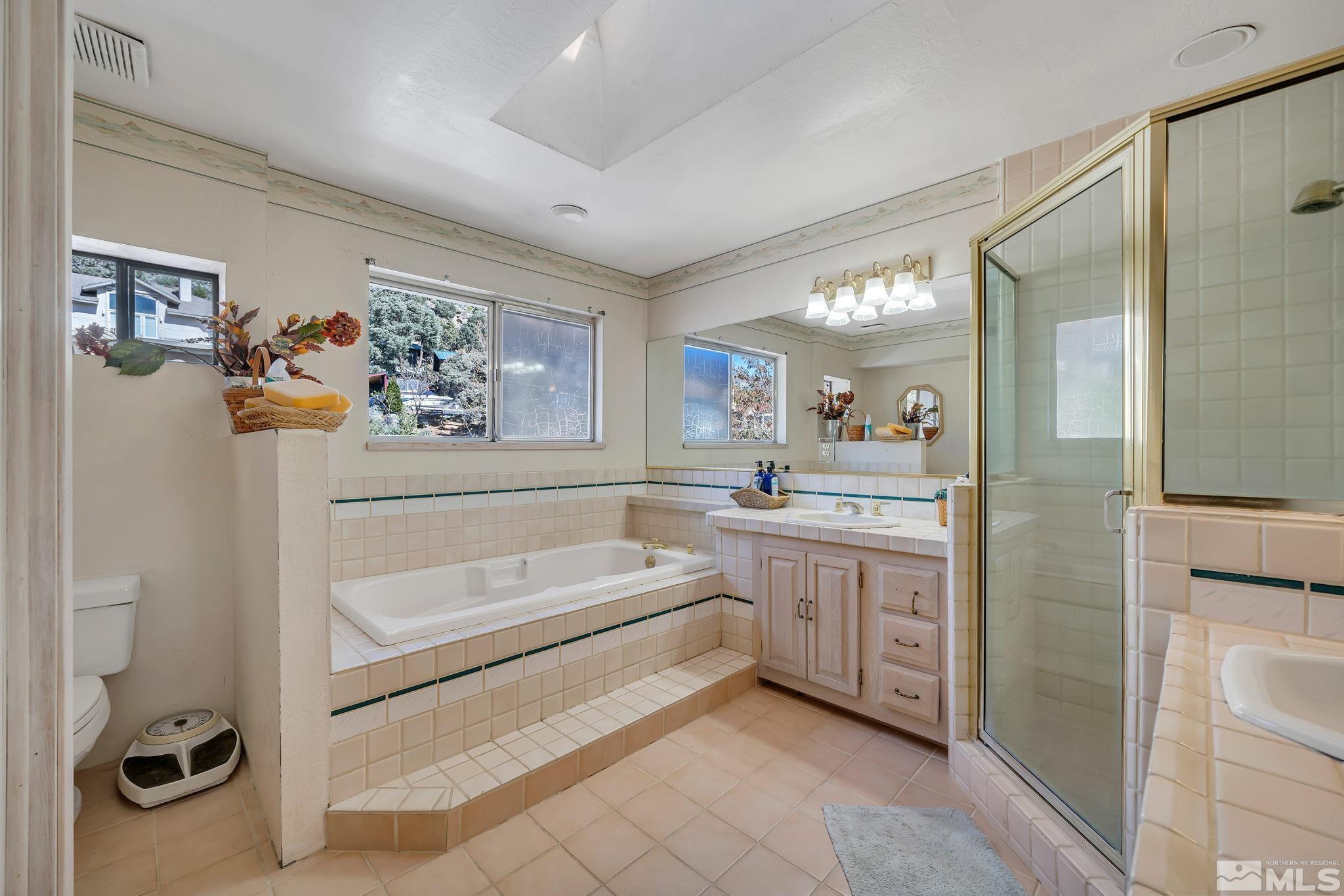 14615 Virginia Foothills Drive Reno, NV 89521 - Photo 21 of 27 a bathroom with a double vanity sink a mirror a window and a shower