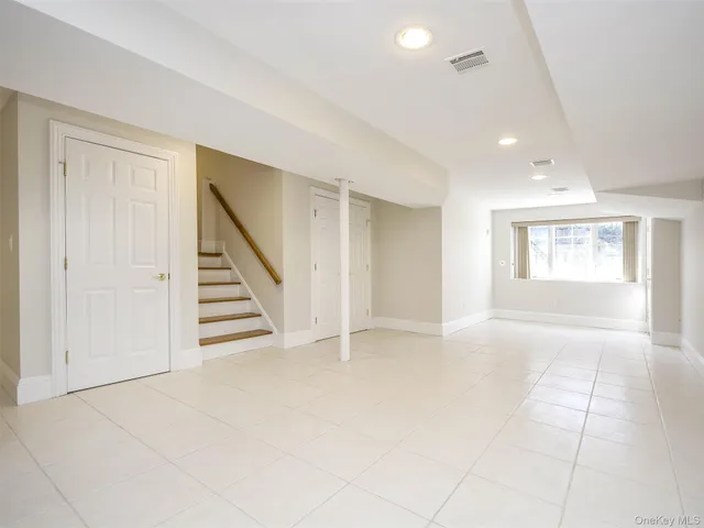 an empty room with windows and stairs
