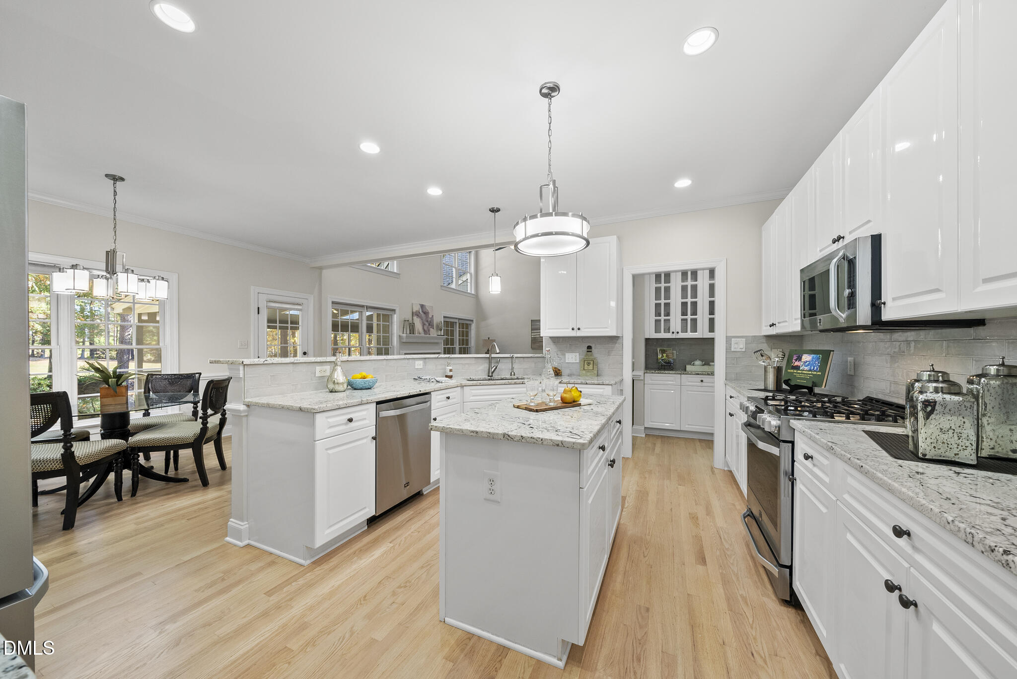 305 Ridge Creek Drive Morrisville, NC 27560 - Photo 12 of 43 a open kitchen with stainless steel appliances granite countertop a stove top oven a sink dishwasher a dining table and chairs with wooden floor