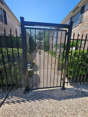 a view of a backyard with a floor to ceiling window and wooden fence