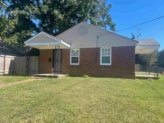 a backyard of a house with table and chairs