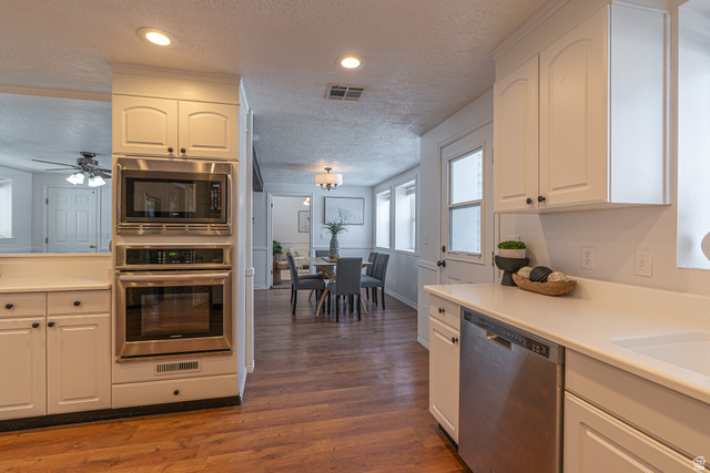 1045 Fox Farm Road Logan, UT 84321 - Photo 21 of 65 Kitchen featuring a textured ceiling, appliances with stainless steel finishes, light countertops, dark wood finished floors, and recessed lighting